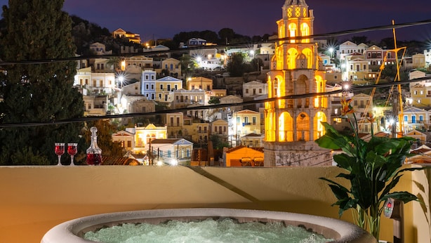 Vista de uma cidade com uma torre imponente e uma banheira de hidromassagem numa varanda.