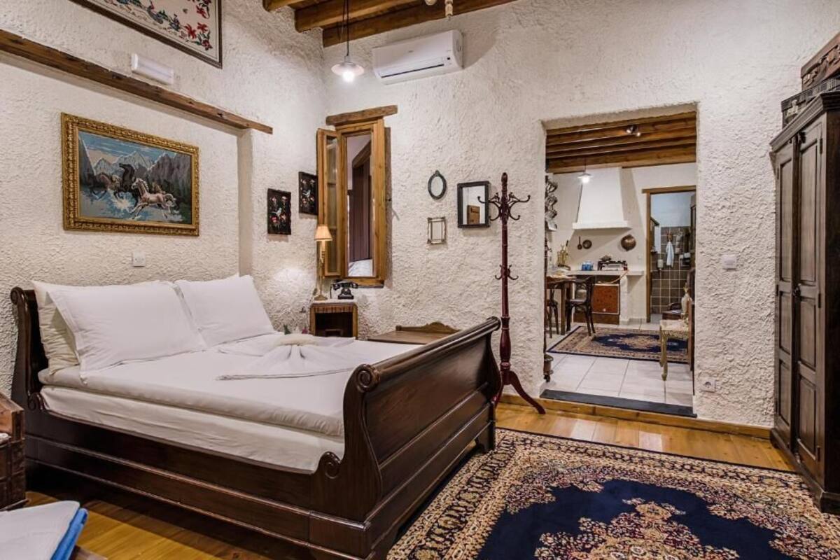 A bedroom with a wooden bed, a mirror, a lamp, and a rug.