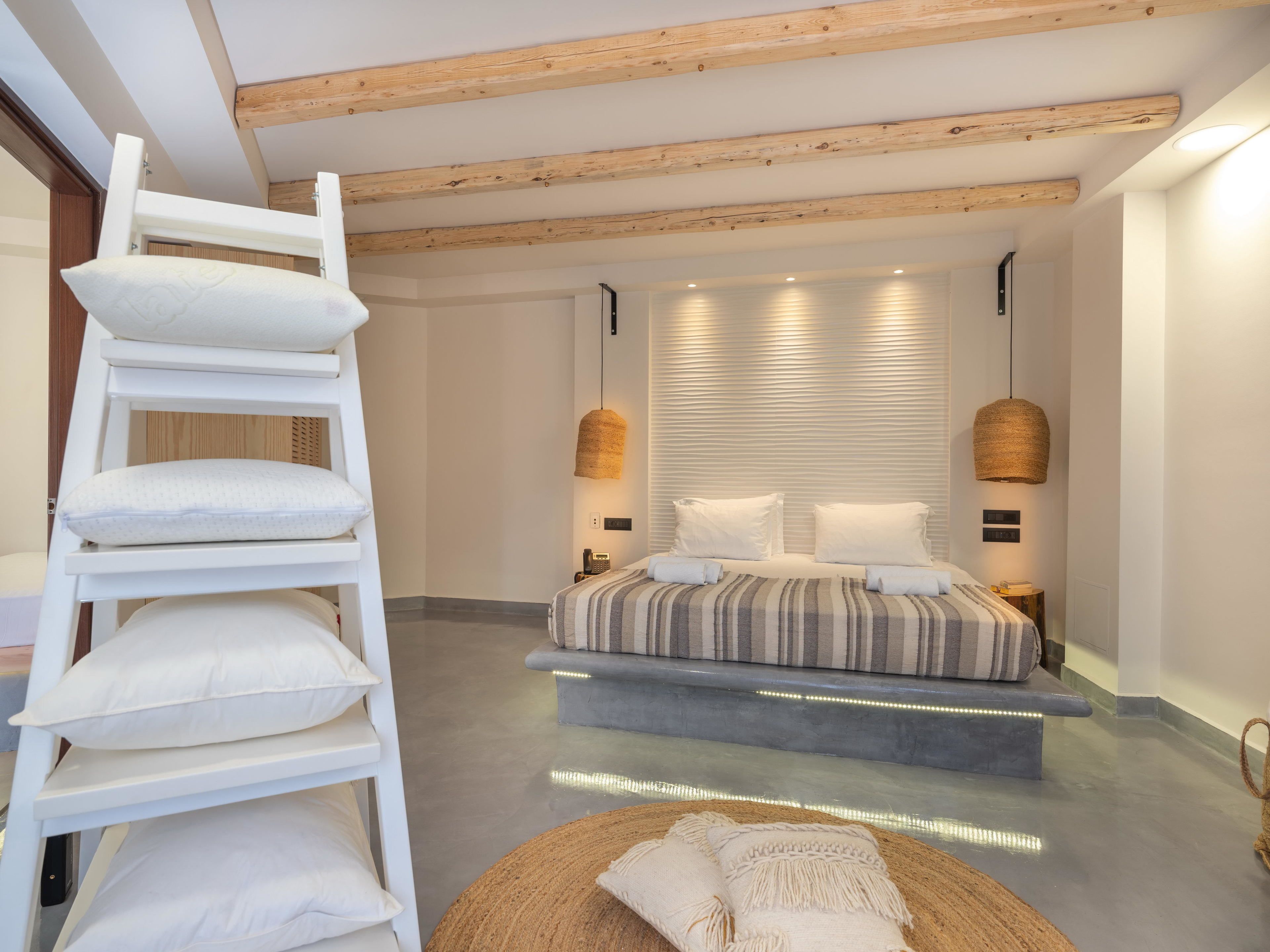 A modern bedroom with a bunk bed, a bedside table, a lamp, and a woven rug.