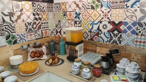 Ein Frühstücksbuffet mit verschiedenen Speisen, einer Kaffeestation und einer Kaffeemaschine.