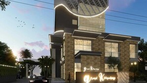 Un hotel moderno con un diseño arquitectónico único, que destaca por una estructura ondulante en la fachada y una entrada bien iluminada.