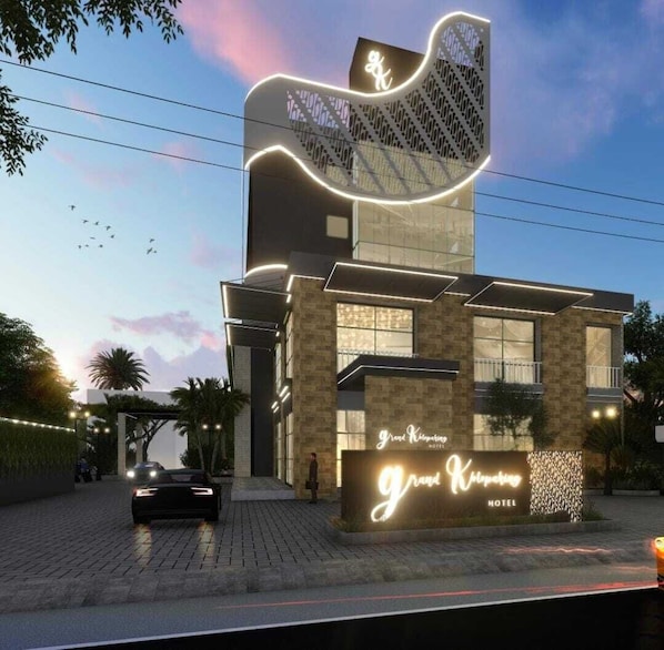Un hotel moderno con un diseño arquitectónico único, que destaca por una estructura ondulante en la fachada y una entrada bien iluminada.