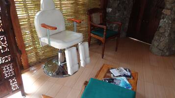 Relax in a traditional room with a wooden chair, white barber chair, and a wooden table.
