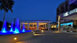 En restaurant ved vandet med udendørs siddepladser og en springvand.