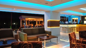 Et moderne loungeområde med sofaer, et sofabord og en bar med skamler.