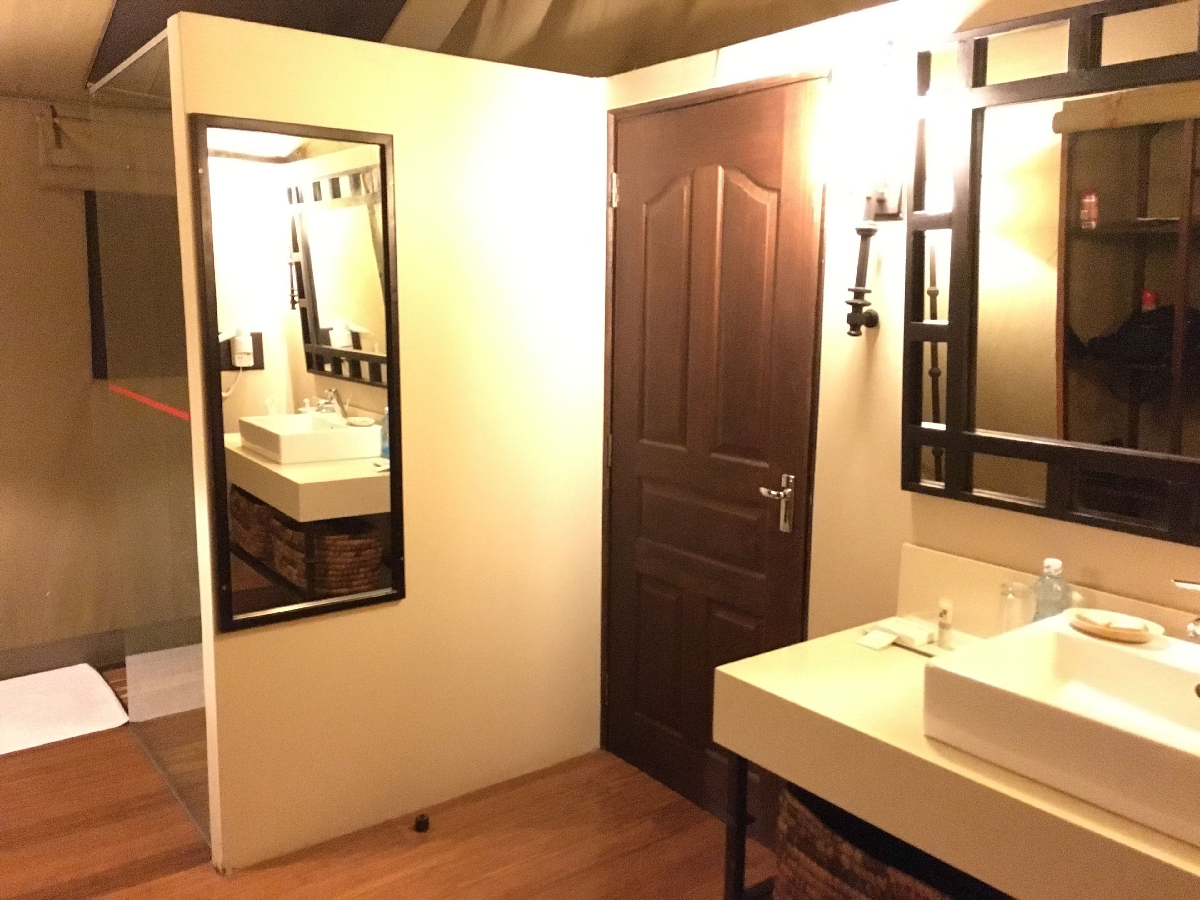 A bathroom with a white sink, a mirror, and a wooden door.