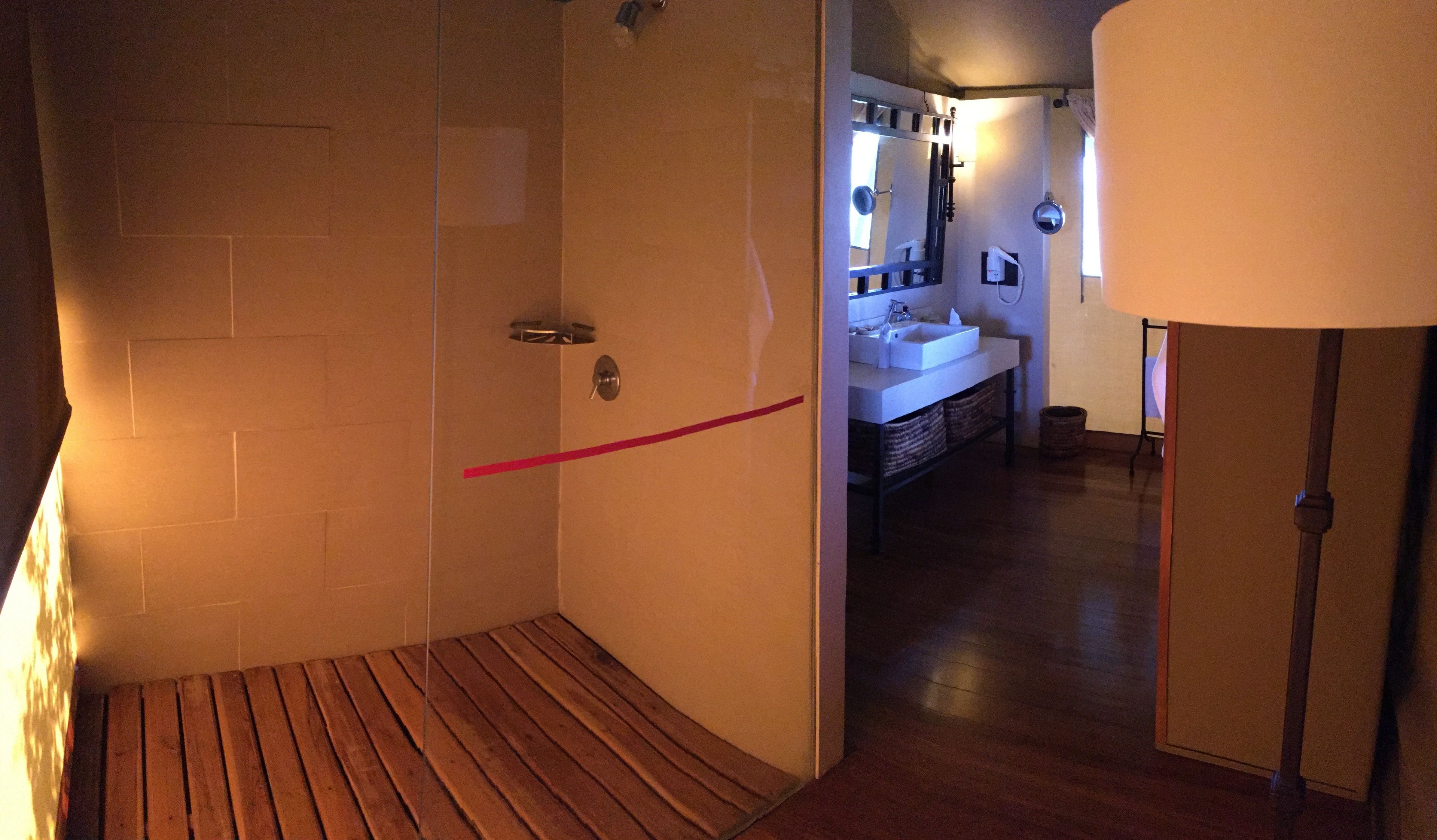 A bathroom with a shower, a sink, and a mirror.