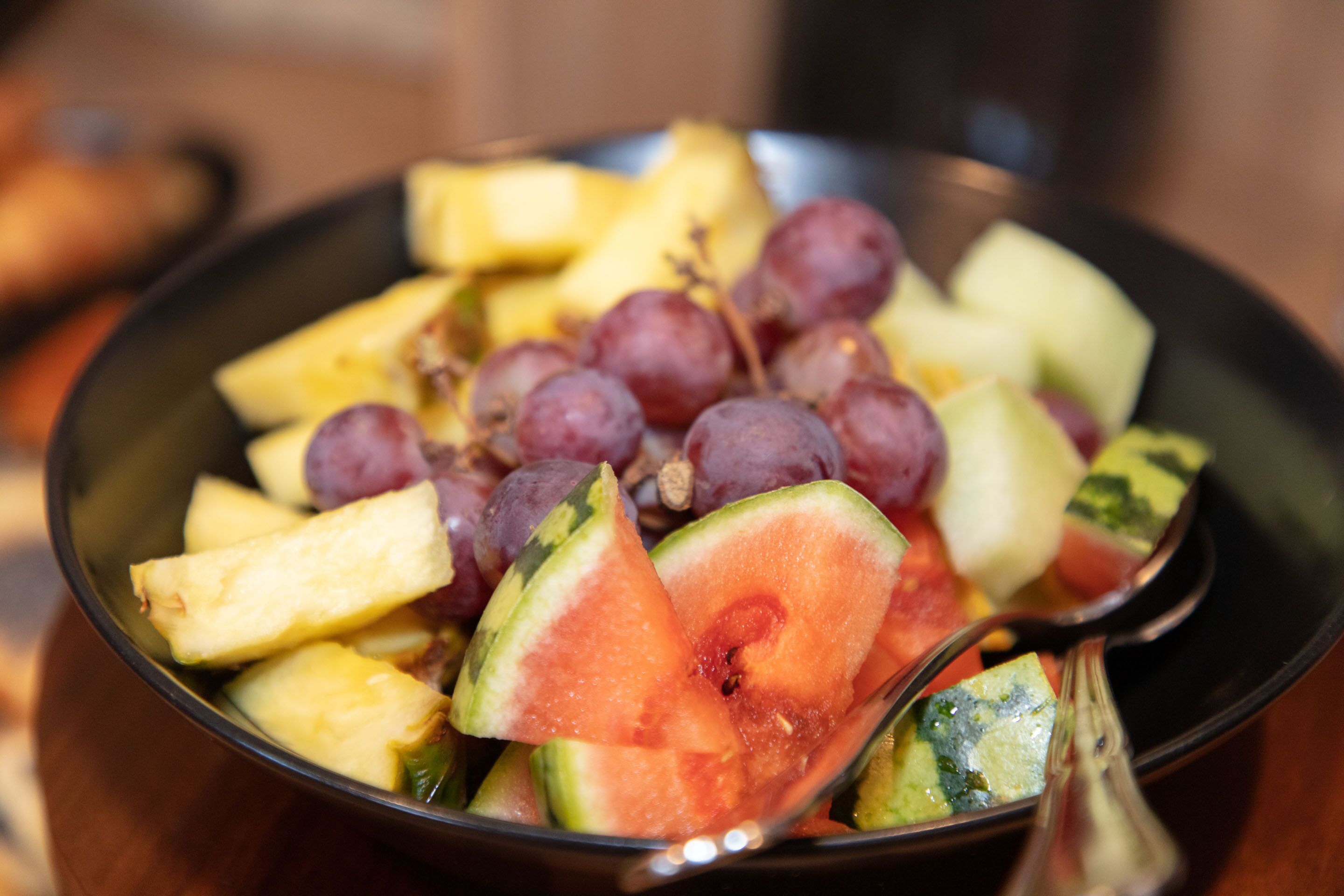 Un tazón de fruta con sandía, uvas y trozos de piña.