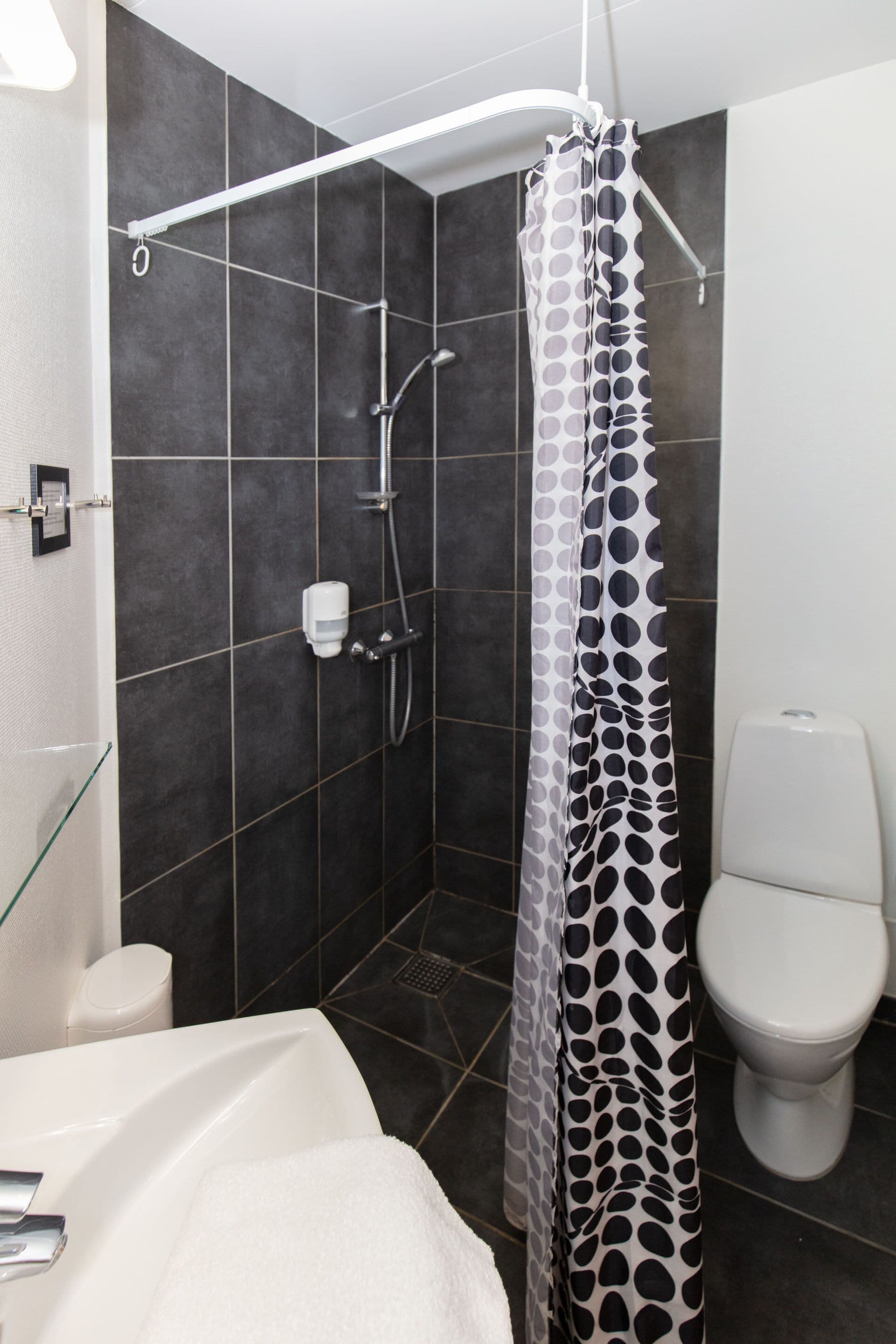Un baño moderno con ducha, inodoro y bañera.