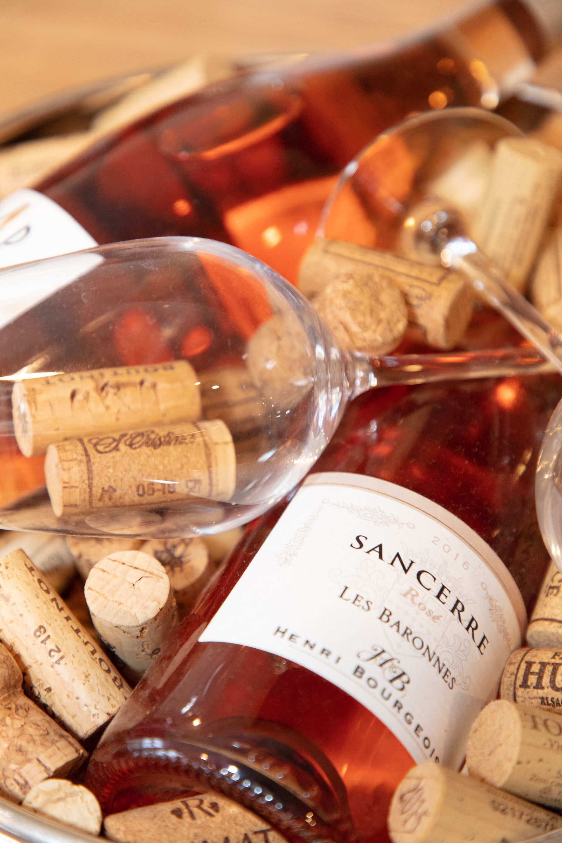 A bottle of Sancerre wine with a label, surrounded by wine corks.