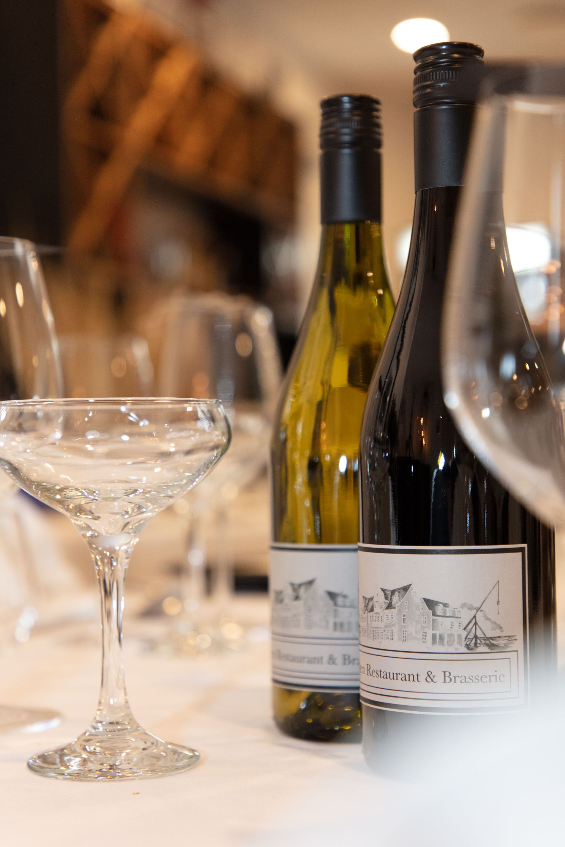 A table with wine bottles and glasses, indicating a dining setting.