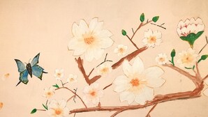 Una rama con flores y una mariposa.