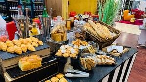 Een buffet met diverse gebakjes, waaronder croissants, gebak en brood.