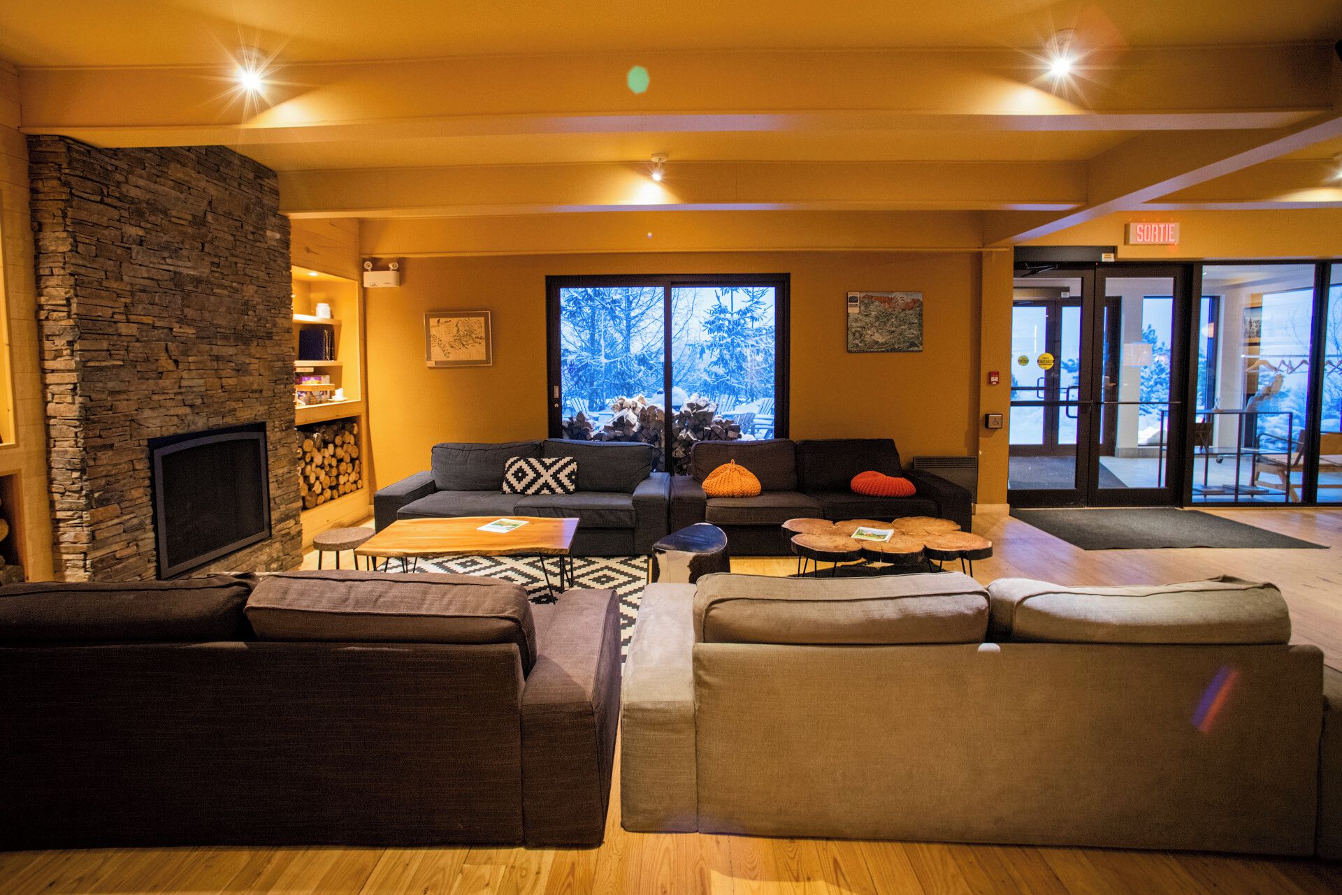 A cozy interior with a stone wall, a fireplace, and a seating area with sofas and a coffee table.