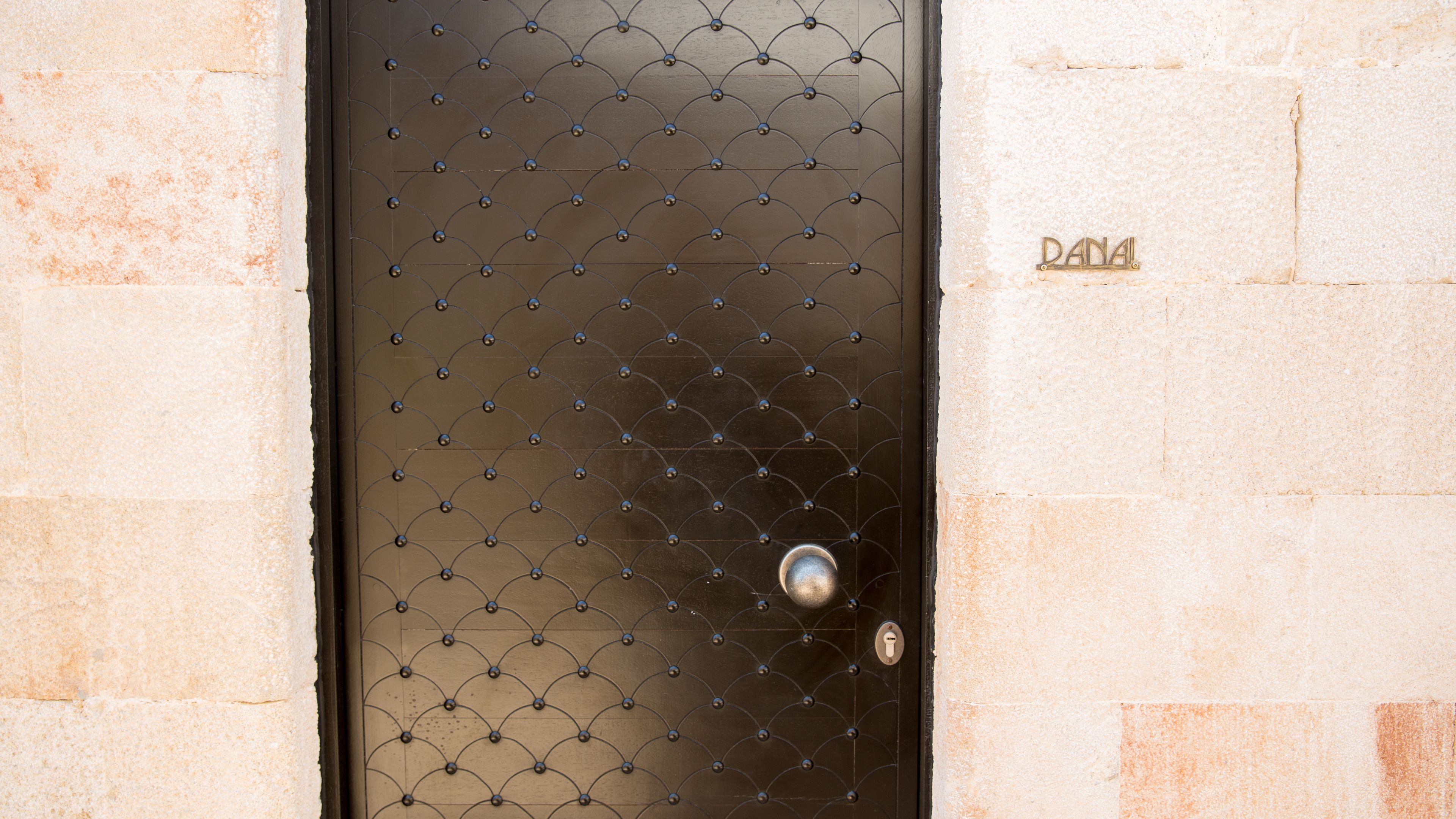 Une porte métallique ornée d’un motif losangé et dotée d’une serrure ronde.
