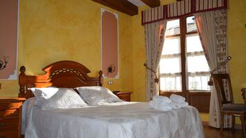 Un dormitorio con una cama de madera, una mesita de noche, una silla y una ventana con cortinas.