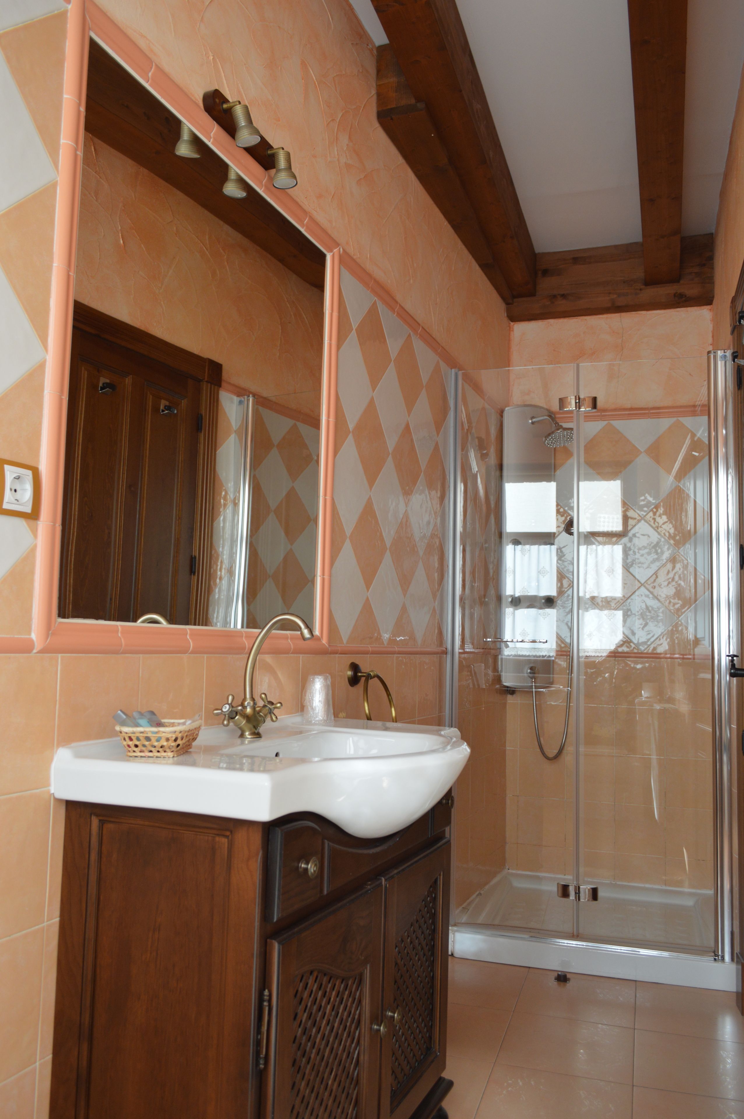 Ein Badezimmer mit einem Holzbadezimmer, einem Waschbecken, einem Spiegel und einer Duschkabine.