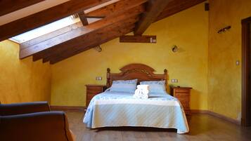 A bedroom with a wooden ceiling, a bed with a quilt, two bedside tables, and a nightstand.
