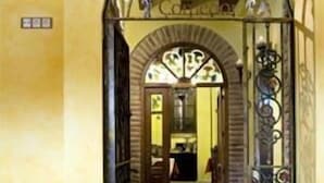 Un pasillo abovedado con piso de baldosas que conduce a una habitación con una puerta.
