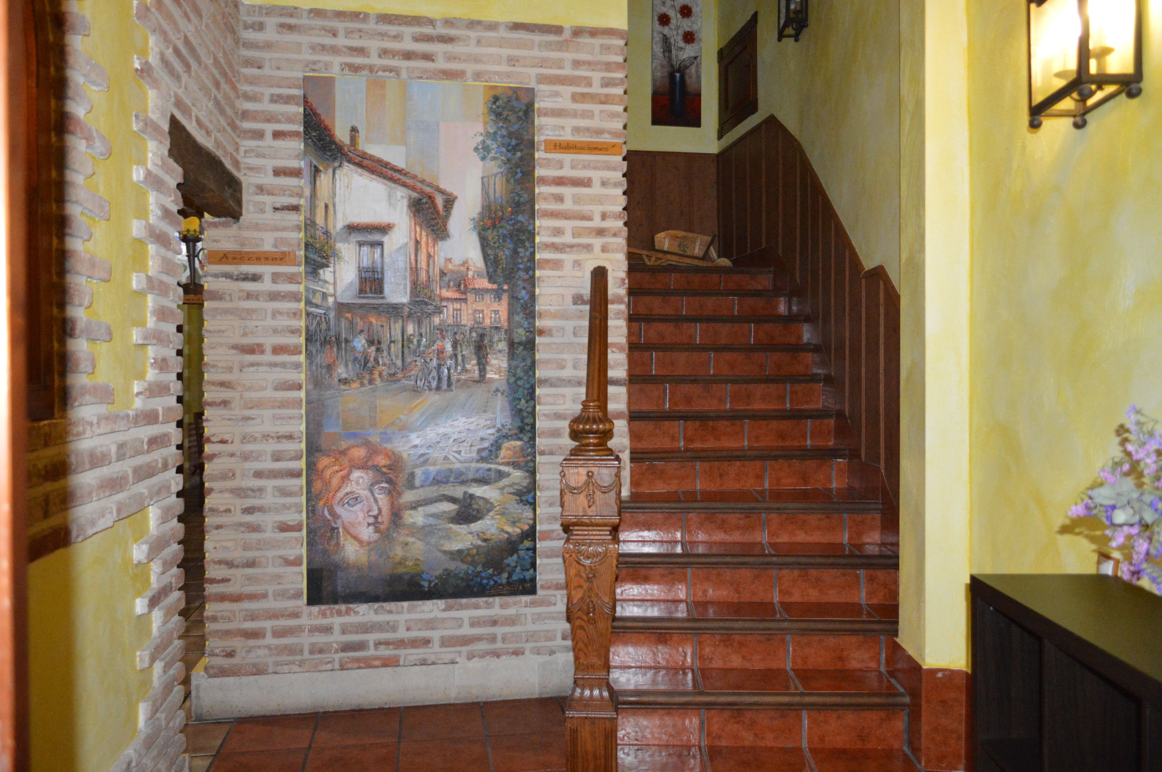 A staircase with a wooden handrail and a mural depicting a street scene.