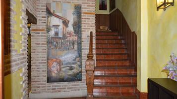 A staircase with a wooden handrail and a mural depicting a street scene.
