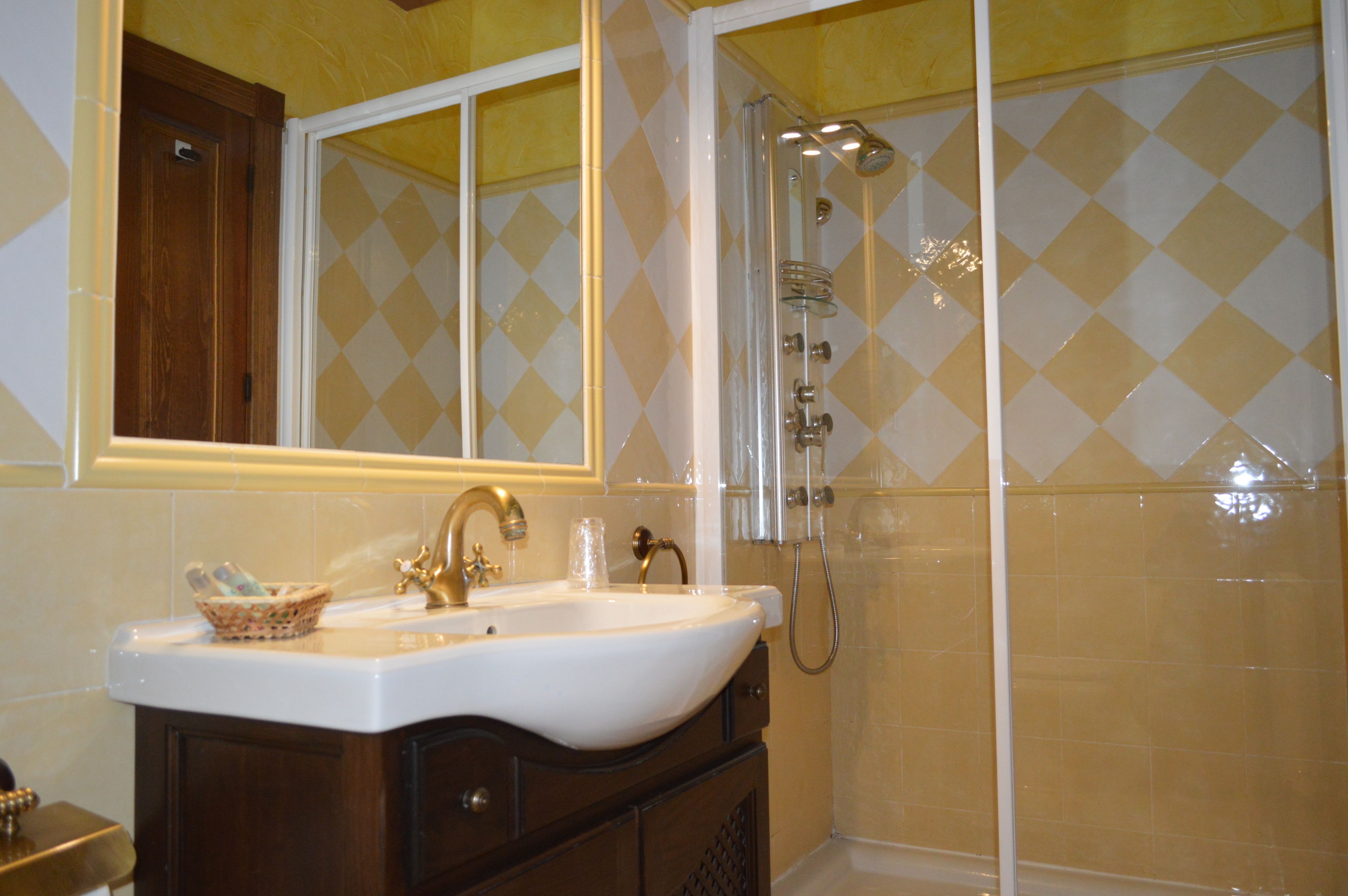Un baño con lavamanos, espejo y ducha.
