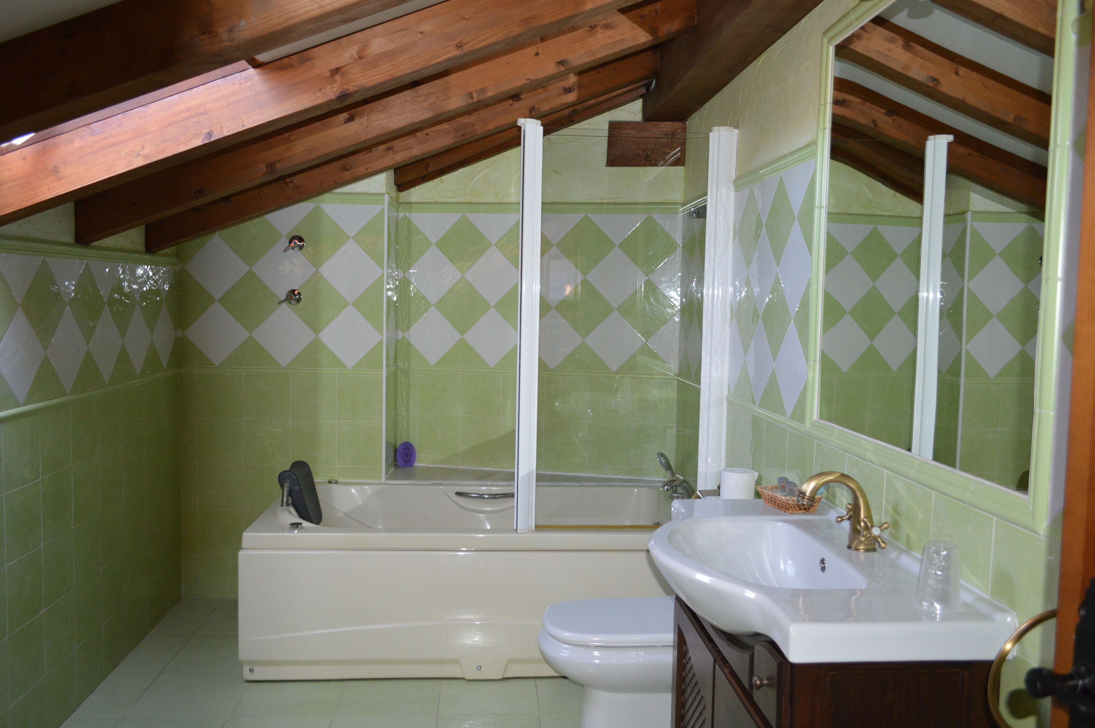 A bathroom with a bathtub, toilet, sink, and a mirror.