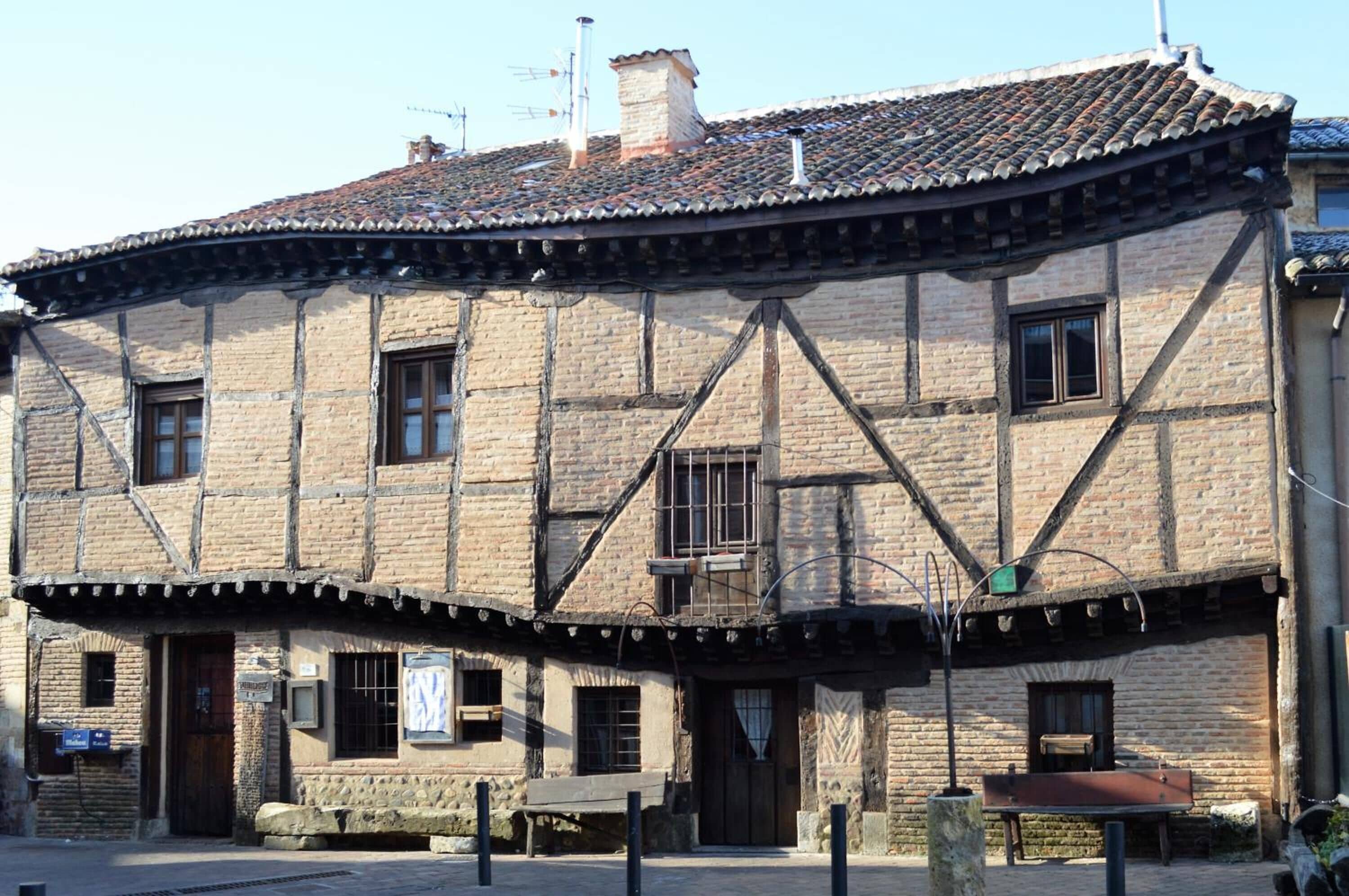 Un bâtiment traditionnel à colombages, avec des poutres en bois apparentes et un toit recouvert de tuiles.