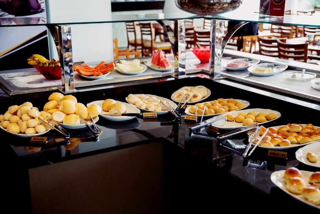 A buffet with various food items including bread, pastries, and fruits.