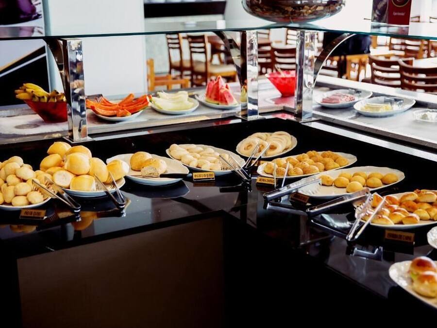 A buffet with various food items including bread, pastries, and fruits.