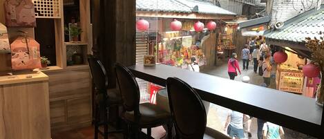 A restaurant with a view of a bustling street market.