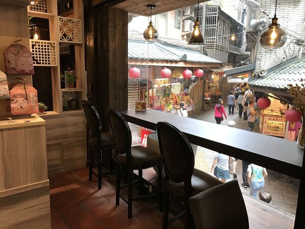 A restaurant with a view of a bustling street market.