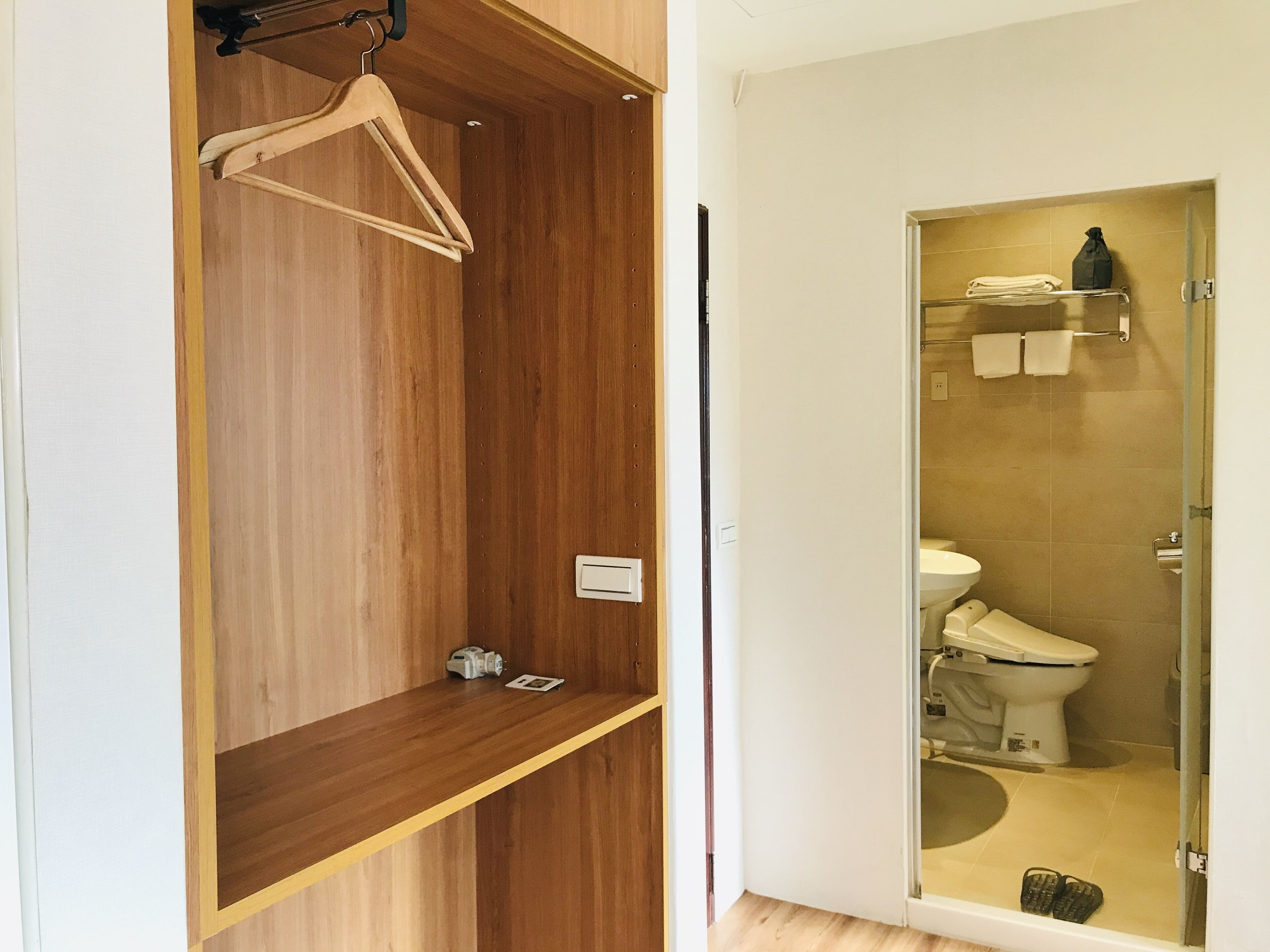 A bathroom with a wooden vanity, a glass shower enclosure, and a towel rack.