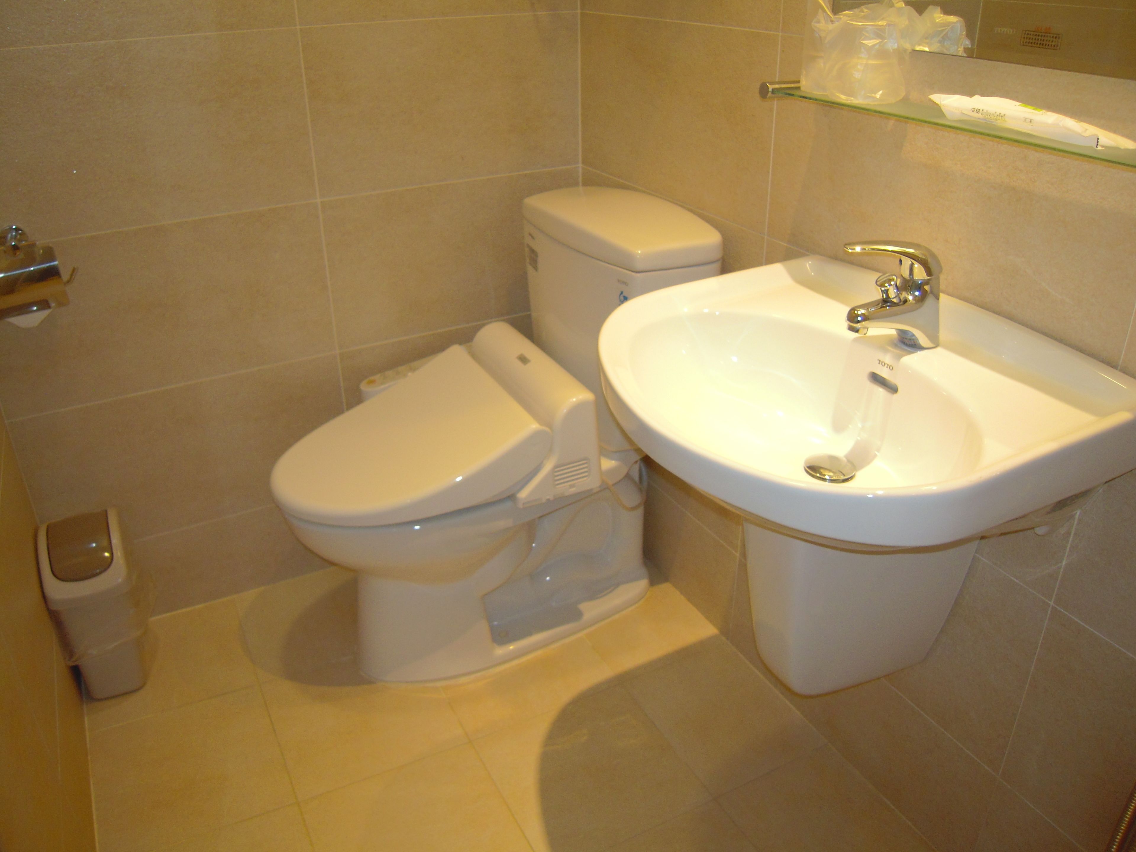 Ein Badezimmer mit Toilette, Waschbecken und Mülleimer.