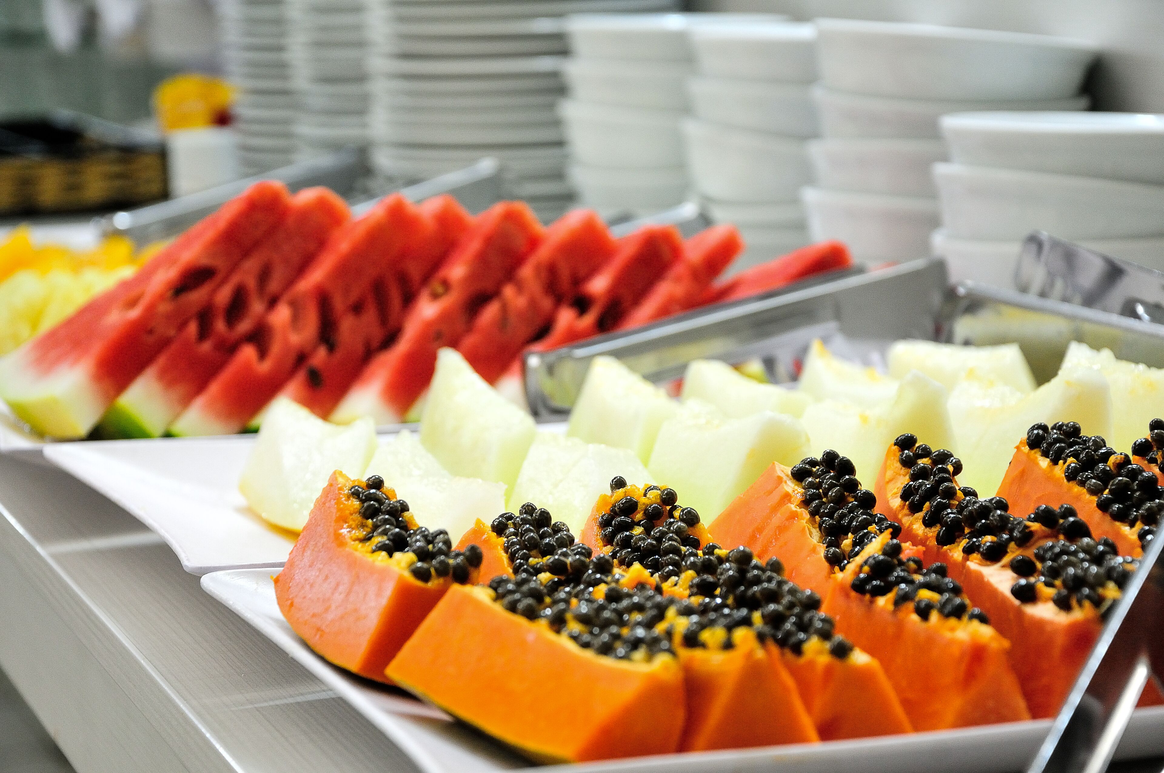 A buffet with various fruits including watermelon, papaya, and pineapple.