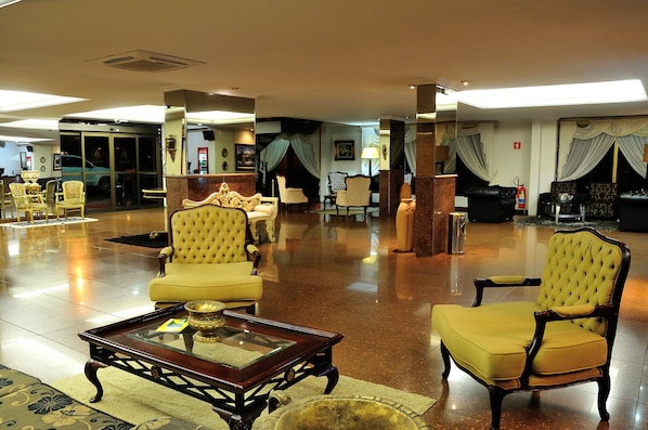 Un hall d’entrée spacieux, doté d’un sol ciré, d’un comptoir de réception et de plusieurs espaces aménagés avec des fauteuils confortables.
