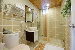 A bathroom with a toilet, sink, mirror, shower, and tiled walls. - Wensinghouse (New Taipei City)