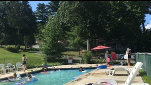 A swimming pool with lounge chairs and a 9 ft deep sign. - Rock Castle Resort (Lake George)
