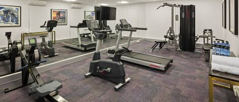 A gym with treadmills, stationary bikes, and weight machines.