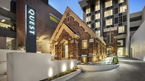 A modern building with a stone facade and a sign reading "QUEST." - Quest East Perth (East Perth)