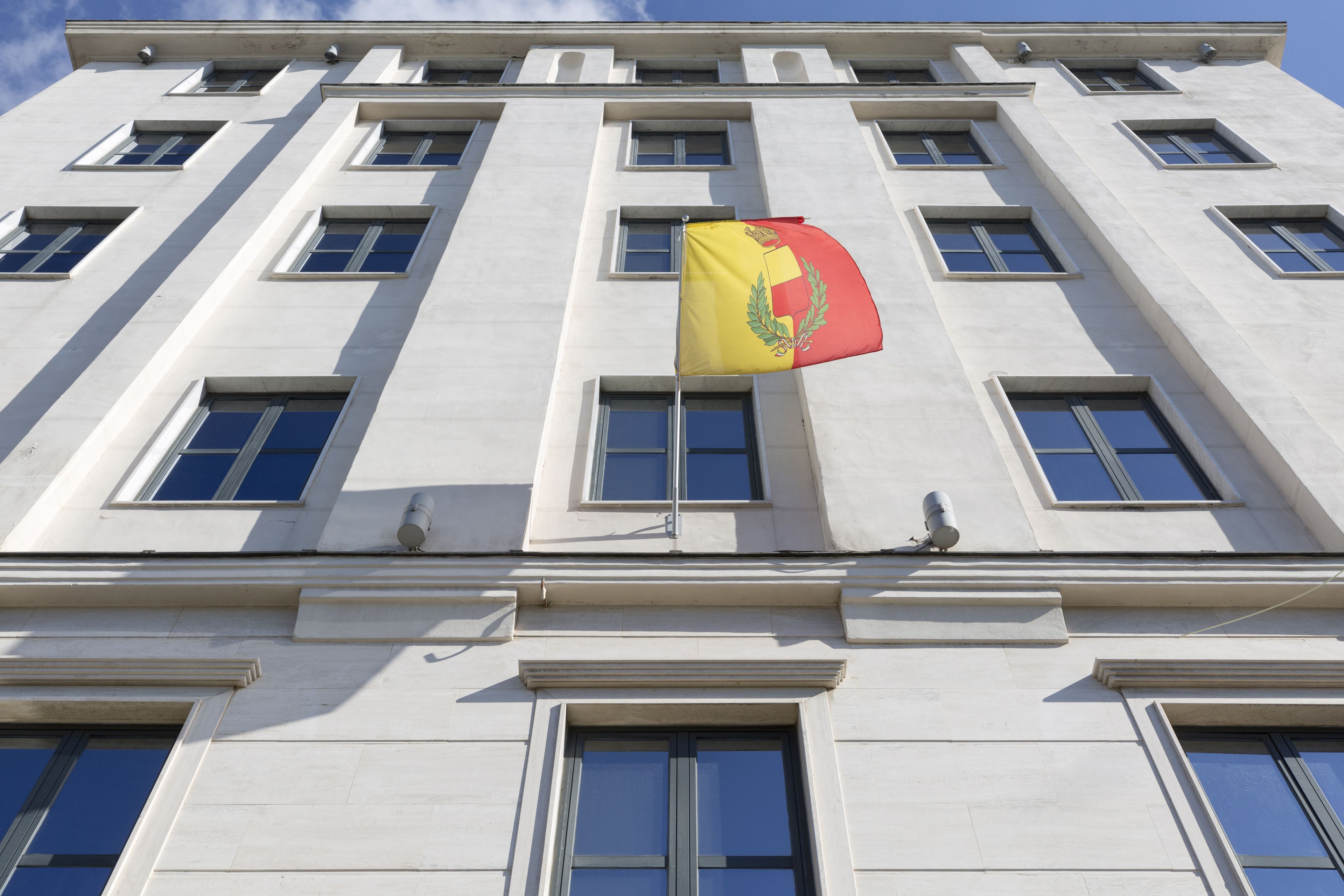A building with multiple windows and a flag.