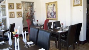 A dining area with a long table set for a meal, surrounded by chairs. - Villaggio Hotel & Restaurant (Warrington)