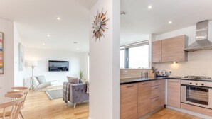 A modern kitchen with wooden cabinets, a built-in oven, and a large window.
