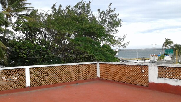 Un balcó amb vista al mar i un cartell que indica el camí cap a Villa del Mar, Moca i Boca del Rio.