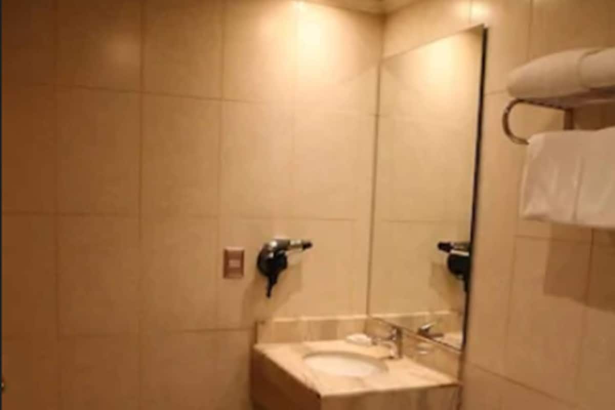 A bathroom with a sink, mirror, toilet, and towel rack.