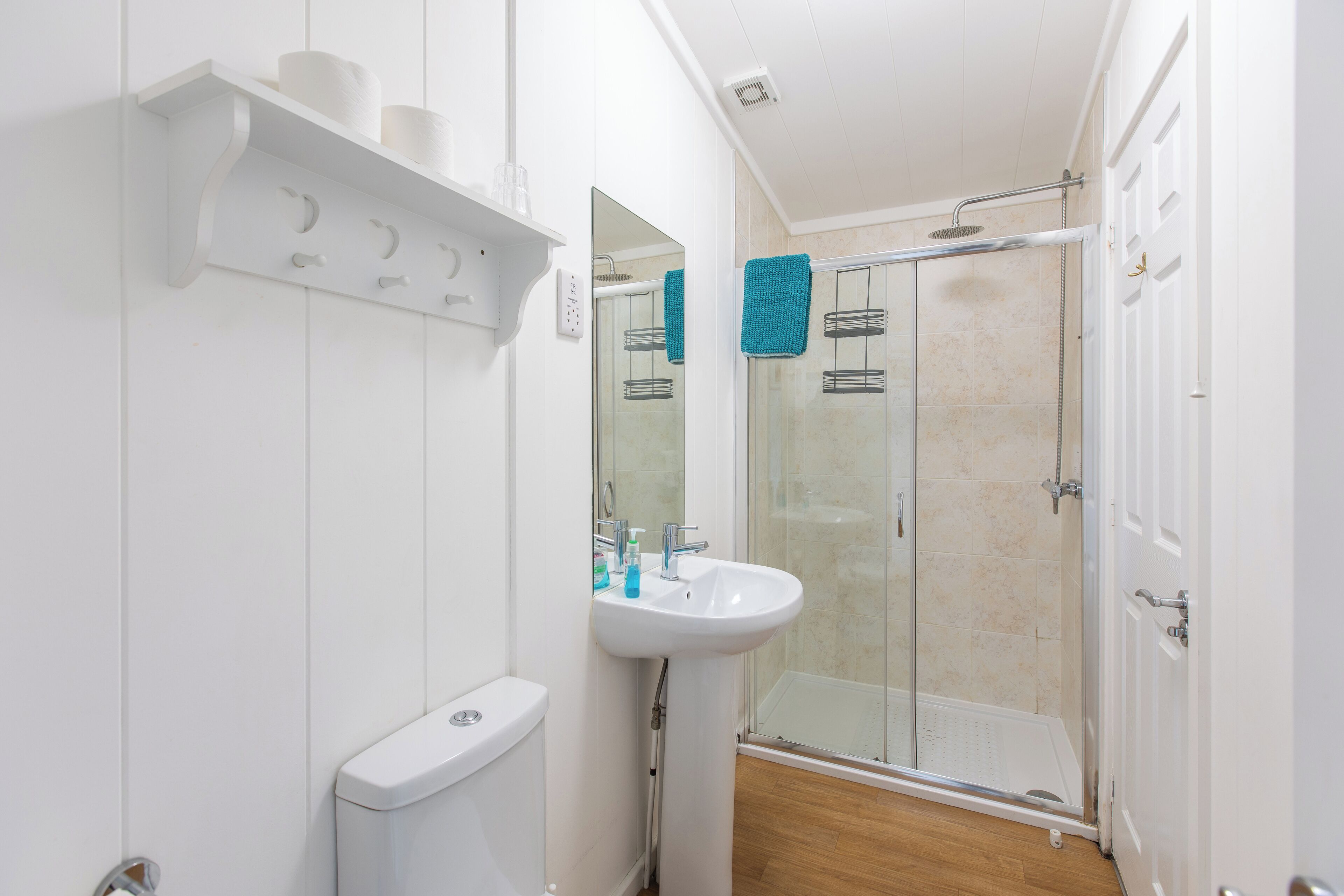 A modern bathroom with a toilet, sink, and glass-enclosed shower.