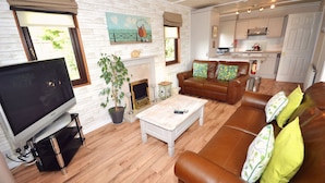 Una sala de estar con televisión, chimenea, sofá y mesa de centro.