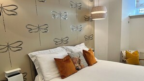 A bedroom with a bed, pillows, a wall-mounted light fixture, and a power outlet. - Crieff Armoury Luxury Self Catering Apartment (Crieff)