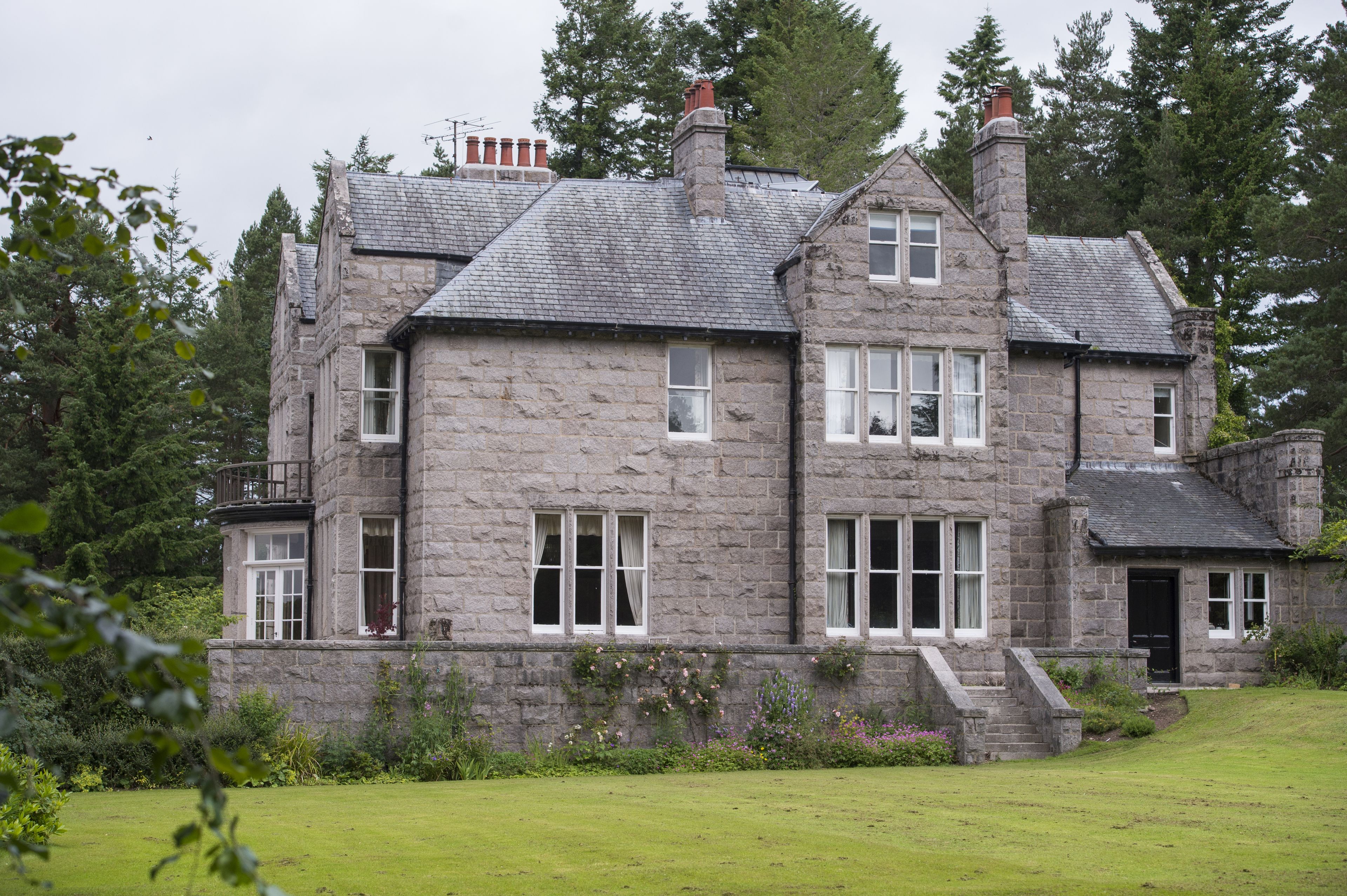 A stone house with multiple windows and a front entrance.