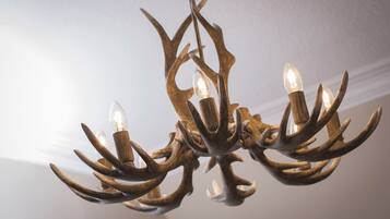A chandelier with antler-shaped metal arms and light bulbs.